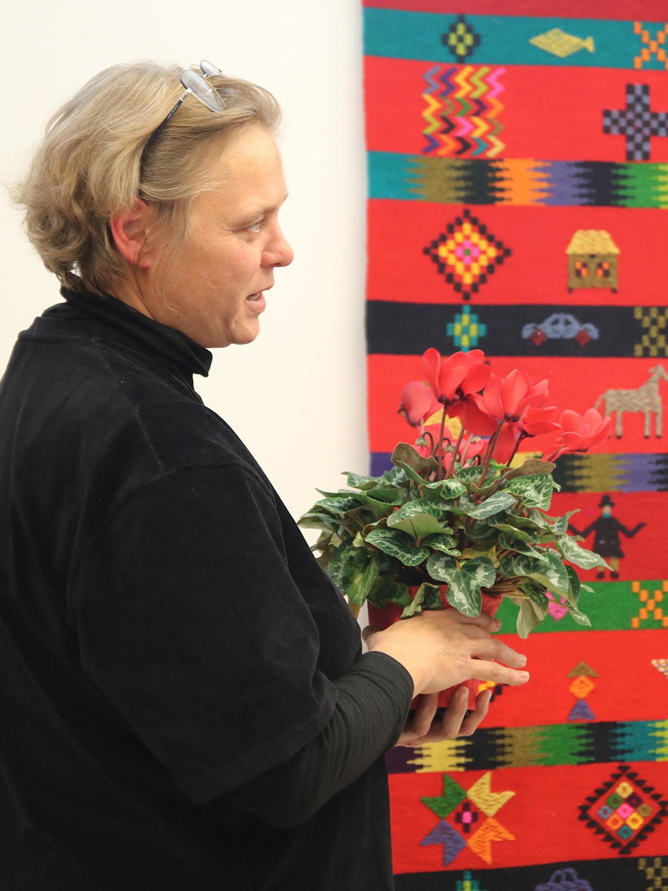 Christi Kütt with the wedding carpet in the background at the opening of the “Hõbevalge – kolme värvi vahel” exhibition at the Pärnu New Art Museum. Photo by Marie Virta.